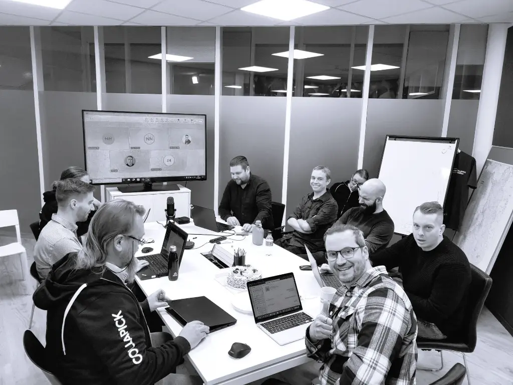 Kuva henkilöstöstä maanantain aamupalaverissa neuvotteluhuoneen pöydän ääressä